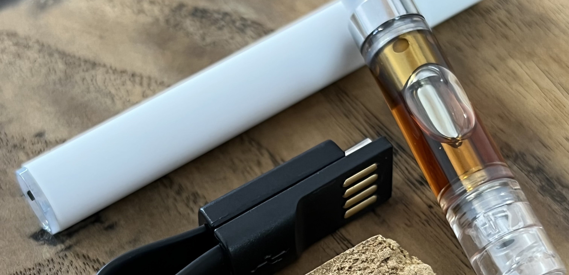 Vaporisateur pour fleurs et résines de CBD posé à côté d'une plaquette